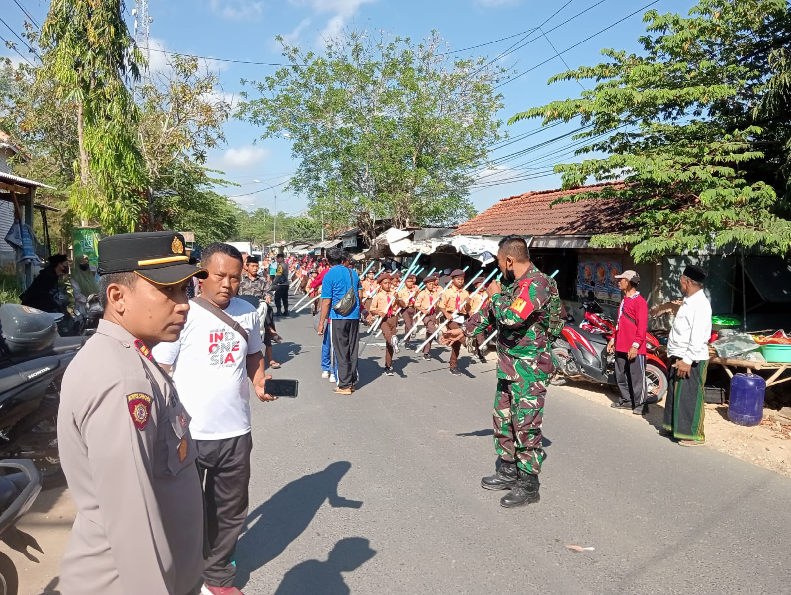 Tingkatkan Keamanan dan Kebersamaan, Babinsa Karang Penang Kawal Lomba Gerak Jalan Tongkat