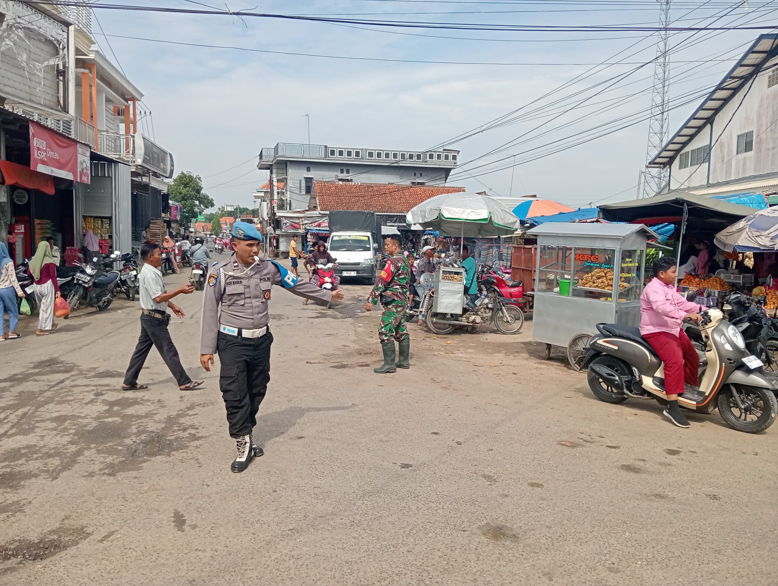 Sinergi TNI-Polri: Babinsa dan Polsek Karang Penang Atur Lalu Lintas untuk Kelancaran Pasar Karang Penang